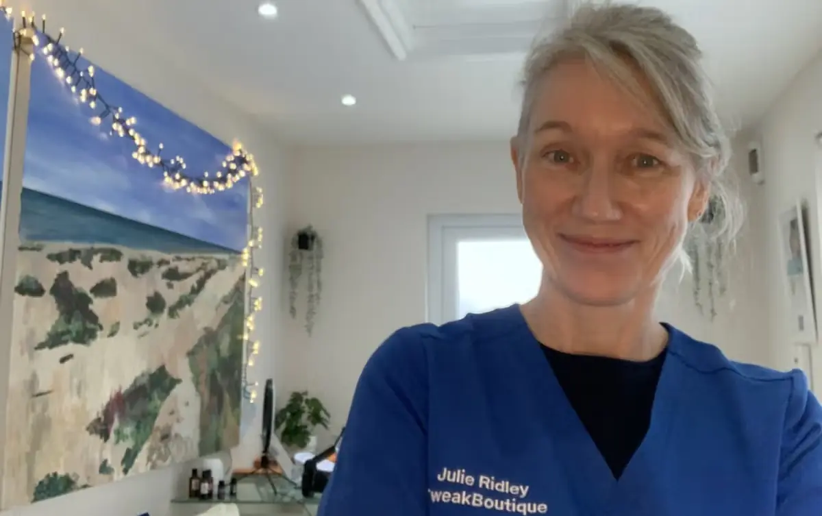 Dr Julie Ridley in her blue TweakBoutique scrubs in her treatment room on Shoreham Beach
